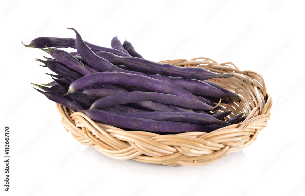 fresh purple beans in rattan basket on white background
