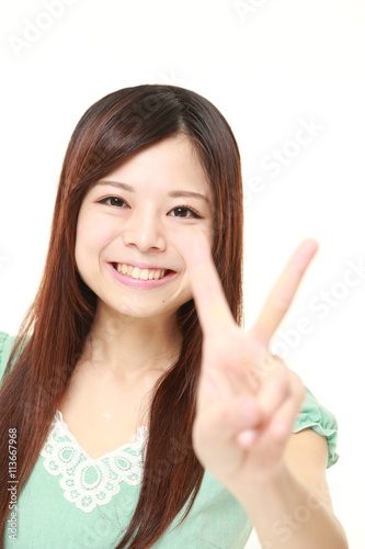 young Japanese woman wearing a green dress showing a victory sign