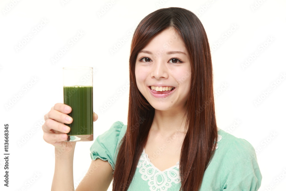 young Japanese woman wearing a green summer dress with green vegetable juice young Japanese woman wearing a green summer dress with green vegetable juice