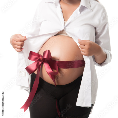 Pregnant belly with red ribbon