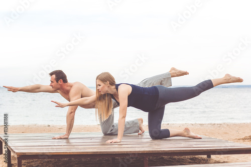 Couple are doing sports at sea coast