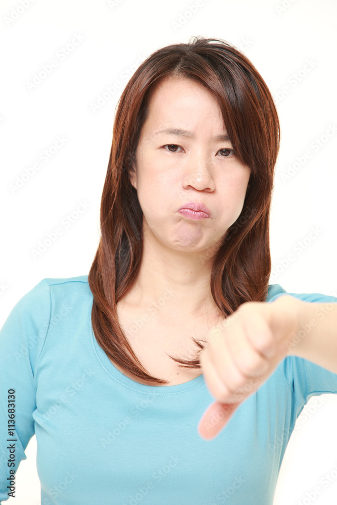 middle aged Japanese businesswoman with thumbs down gesture middle aged Japanese businesswoman with thumbs down gesture