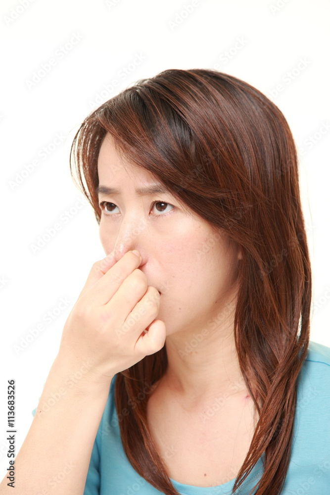 middle aged Japanese woman holding her nose because of a bad smell middle aged Japanese woman holding her nose because of a bad smell