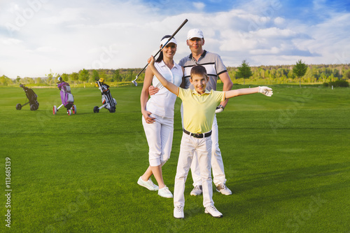 Happy boy golfer plaing golf with parents photo