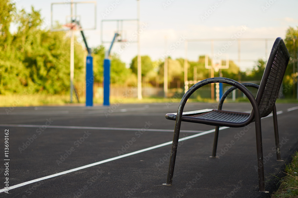 Naklejka premium Bench near backetball court.