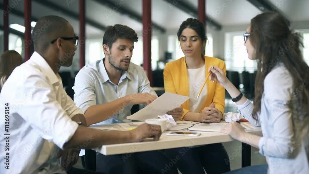Young business partners discussing ideas or project at meeting in office