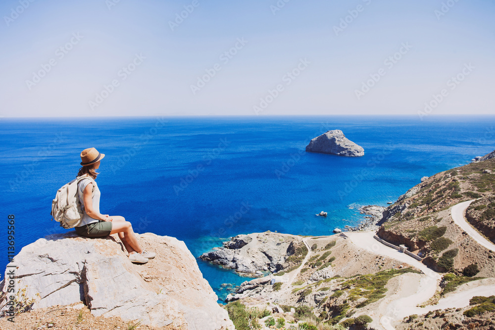 Female traveler woman looking at the sea, travel and active lifestyle concept