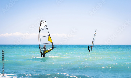 Windsurfing sails on the blue sea