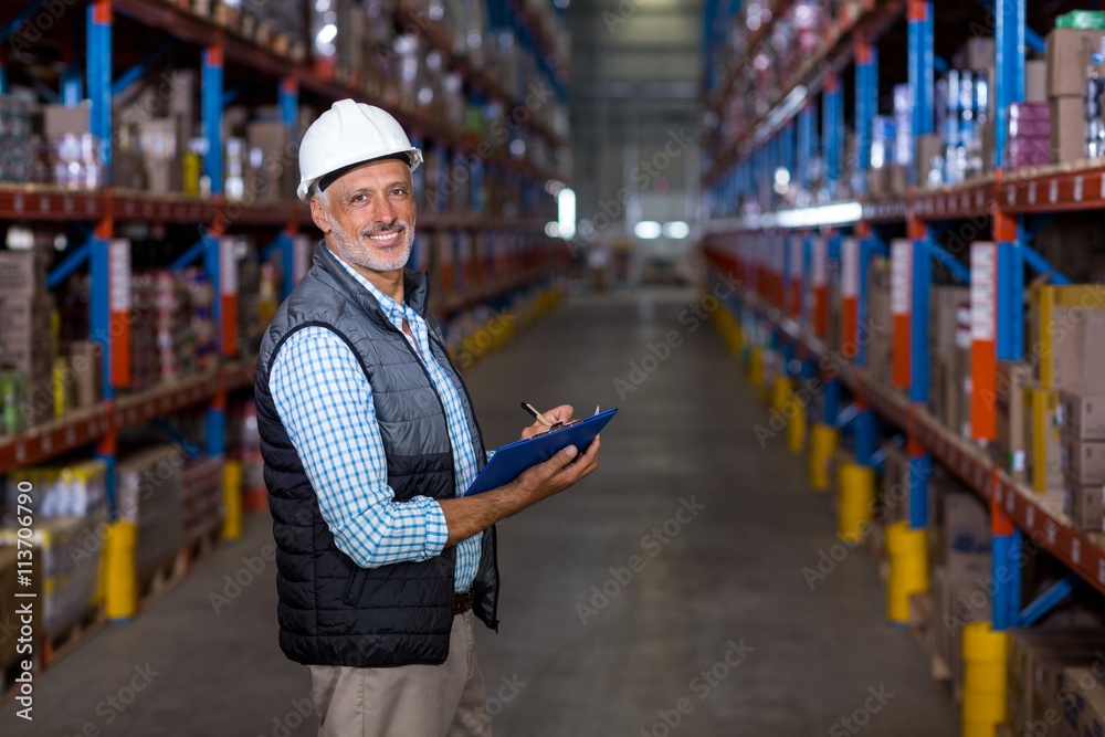 Happy manager holding a clipboard and posing during work Happy manager holding a clipboard and posing during work