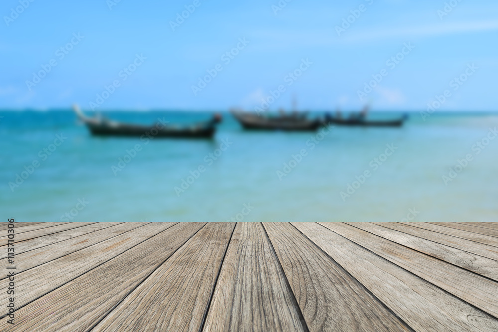 Fototapeta premium Wood table top with blurred nature scene tropical beach and long tail boat