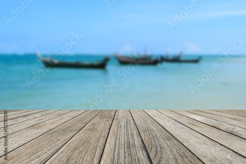 Wood table top with blurred nature scene tropical beach and long tail boat © aon_skynotlimit