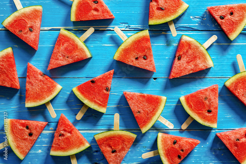 Watermelon slice popsicles on a blue rustic wood background, Pop