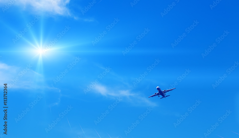jet modern plane comes in to land on the background of sky and sun jet modern plane comes in to land on the background of sky and sun