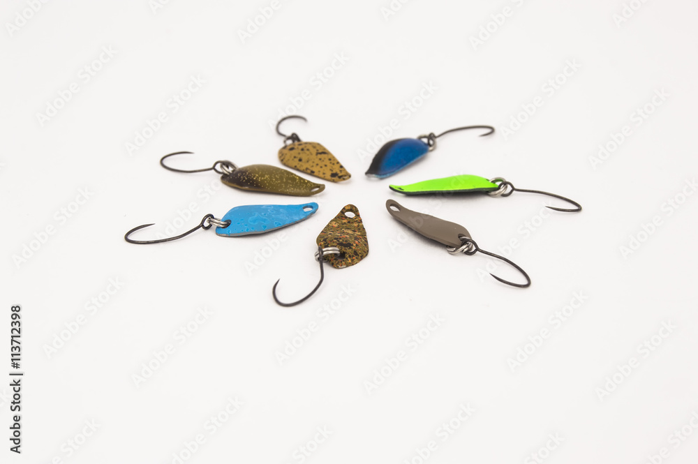 Colored trout fishing lures (spoon lures) for catching lake or rainbow trout,  equipped with barbless hooks, on a uniform white background in the form of  a flower. Tackle for trout fishing Stock