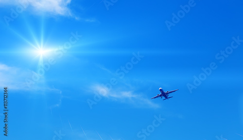 jet modern plane comes in to land on the background of sky and sun