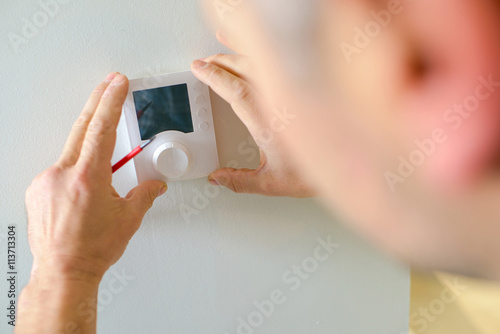Electrician fitting a thermostat