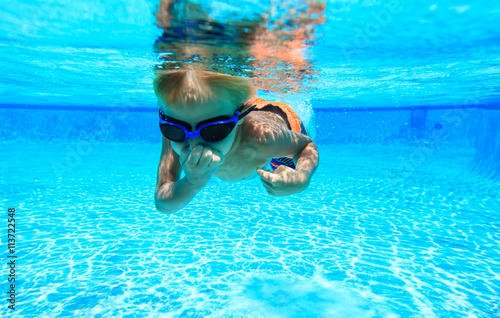 little boy learns swimming underwater