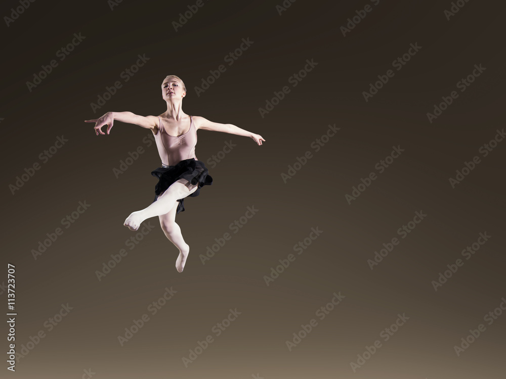 Young beautiful ballerina on dark background