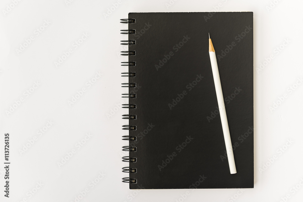 white pencil with black notebook on white white pencil with black notebook on white