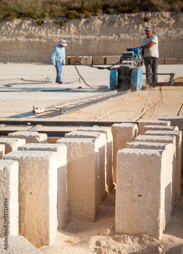Just cut tufa blocks while workers are using a sawing machine to cut the stone vertically