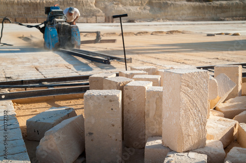Just cut tufa blocks while workers are using a sawing machine to cut the stone vertically