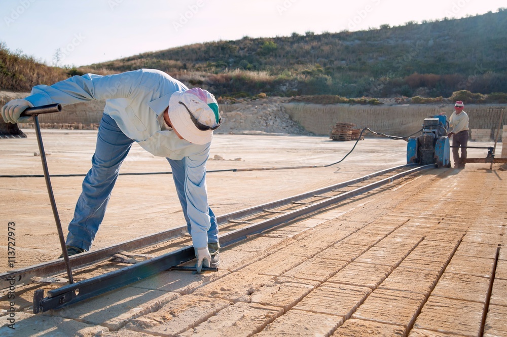 Tufa stone quarry: worker setting the track for the vertical sawing machine Tufa stone quarry: worker setting the track for the vertical sawing machine