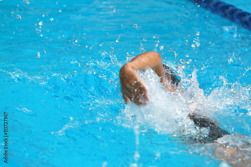 Asian teen swimmer practice forward crawl in a swimming pool for competition  rear side view