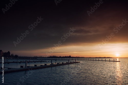 Harbor without ships at sunset © Adga