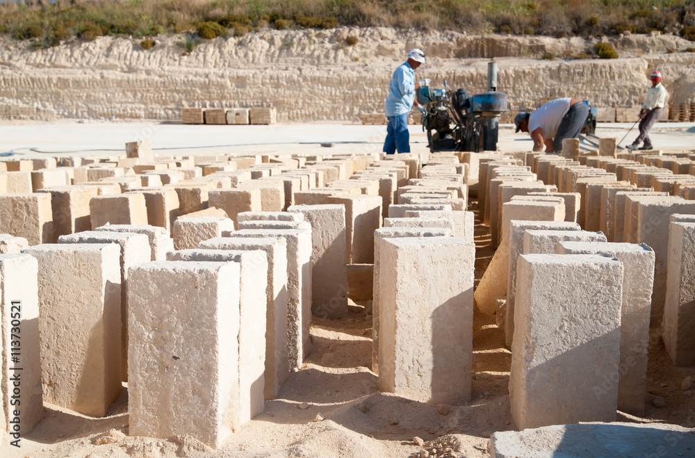 Just cut tufa blocks while workers are using a sawing machine to cut the stone vertically