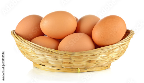 Brown eggs in the basket on white background
