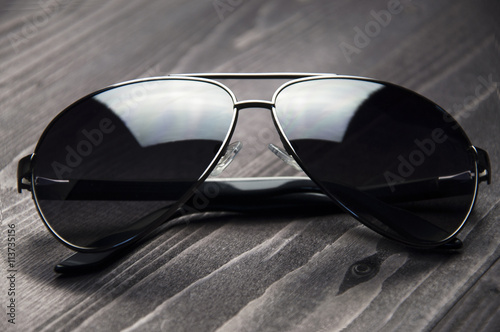 Fashionable dark sunglasses on a wooden table