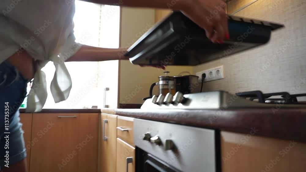 A baking tray being placed in a stove A baking tray being placed in a stove