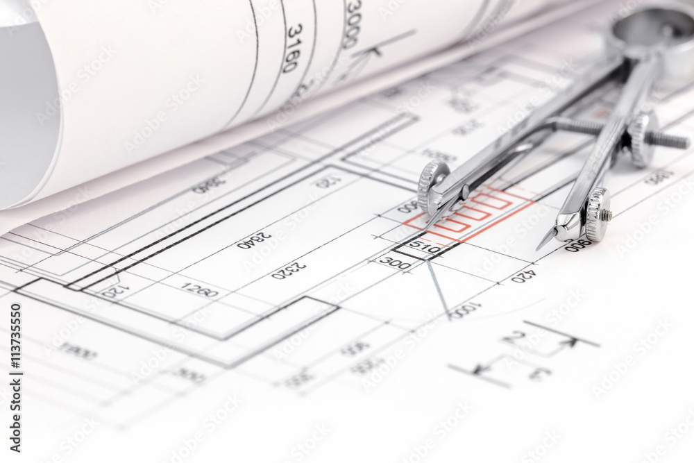 floor plan with rolled blueprint and drawing compass