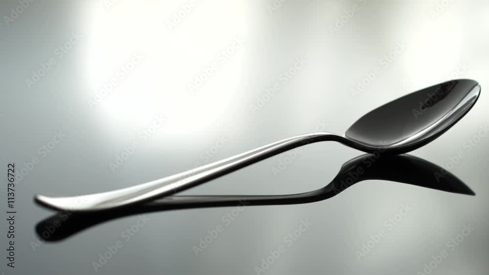 A spoon beeng placed on a reflecting table, shallow focus A spoon beeng placed on a reflecting table, shallow focus