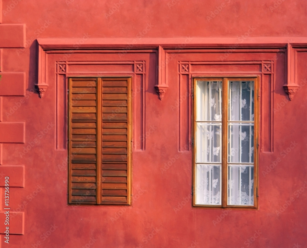 color detail photography of two windows in red wall of historical building