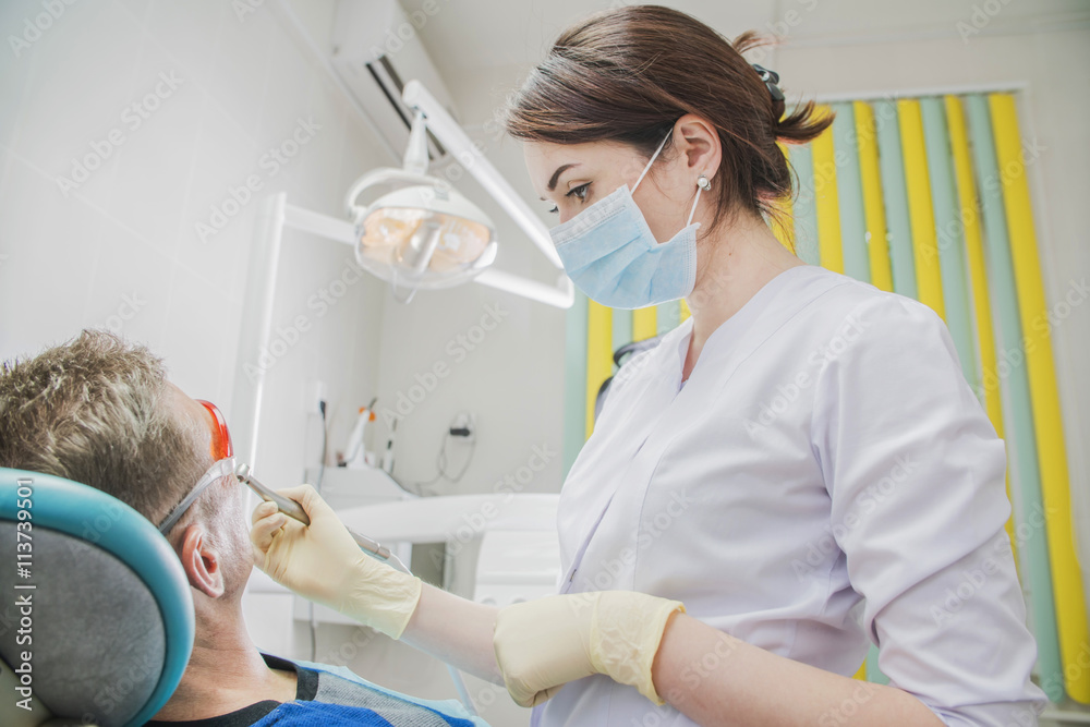 female dentist doctor holding dental drill, patient in the dentist's chair female dentist doctor holding dental drill, patient in the dentist's chair