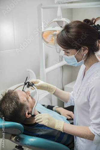 dentist doctor puts on the patient dental front arc