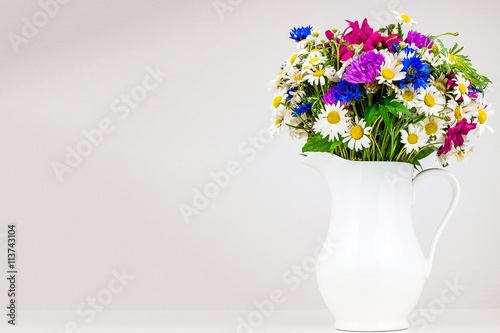 Wildflowers in white ceramic jug.