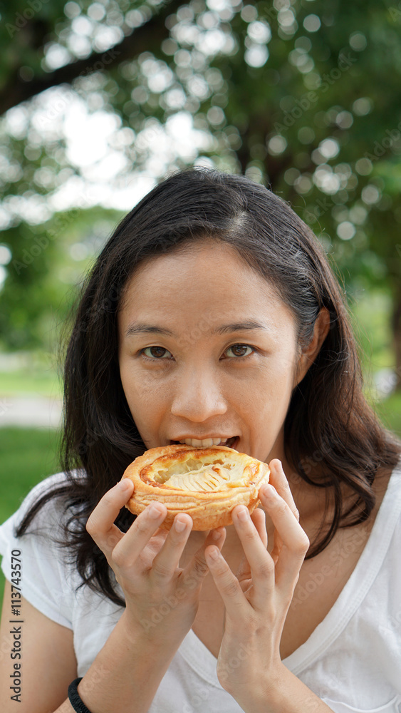 Asian woman mature adult eating bread carbohydrates Asian woman mature adult eating bread carbohydrates