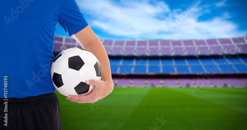 football player holding soccer ball on field of big stadium © Di Studio