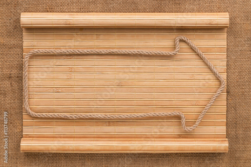 Arrow made of rope lying on a bamboo mat in the form of a manuscript