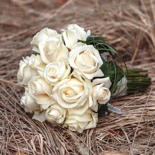 Bridal bouquet of white roses on a faded grass