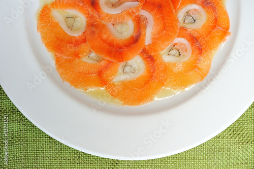 image of raw and fresh salmon sliced topped on ice in dish