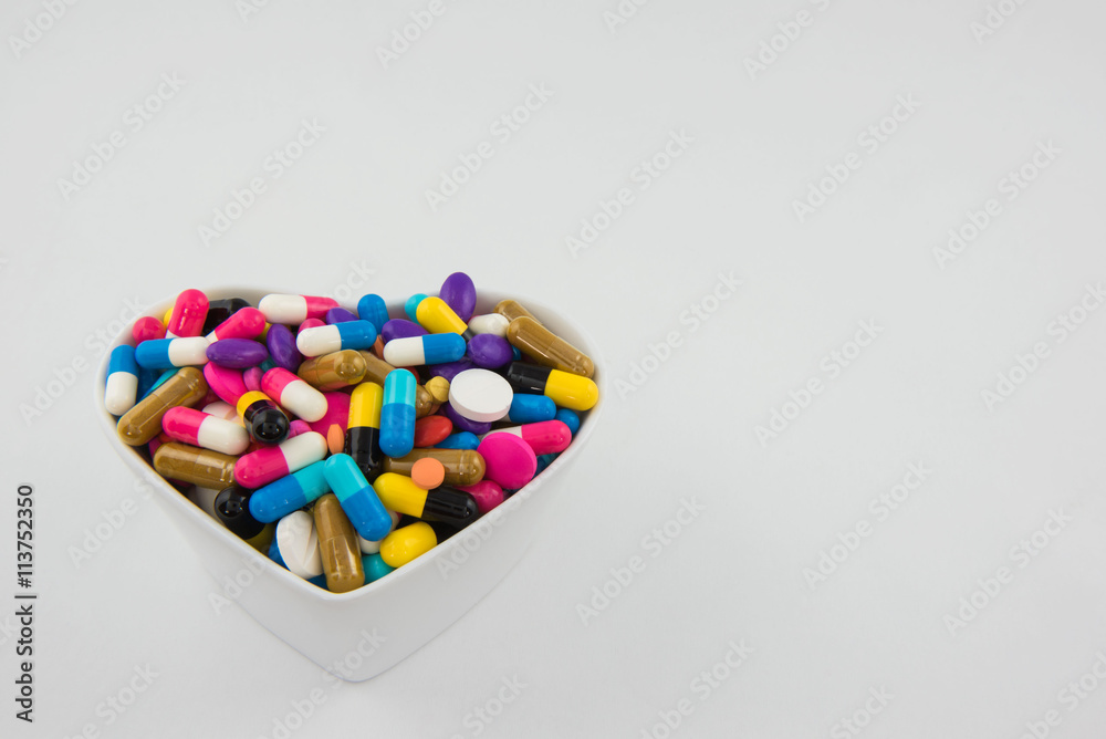 Colorful pills and capsule in a cup on white background Colorful pills and capsule in a cup on white background