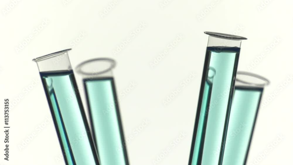 Test tube filled with bleu liquid, pouring a drop of water Test tube filled with bleu liquid, pouring a drop of water