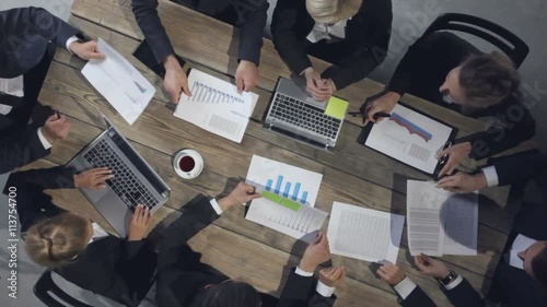 Business people discussing the charts and graphs showing the results of their successful teamwork