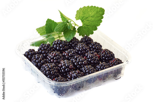 Photos punnet of blackberries with mint branch on white