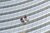 Uomini che lavano i vetri di un grattacelo a Milano