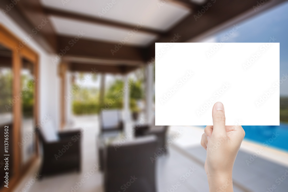 hand holding blank paper with interior background hand holding blank paper with interior background