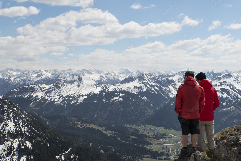 two hikers enjoying view over the alps